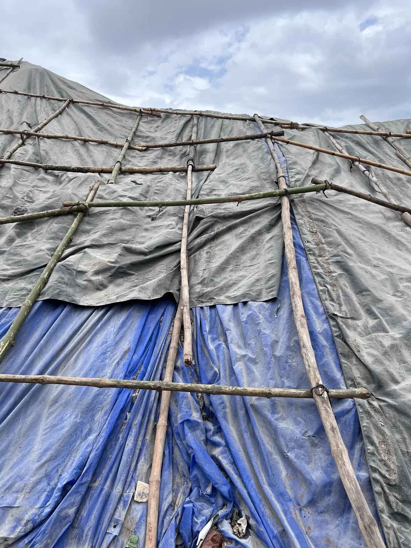 Bamboo-Framed Tarpaulin Covering a Raw Material Stockpile, Close-Up
